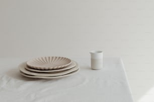 Ein Stapel Teller, der auf einem weißen Tisch sitzt