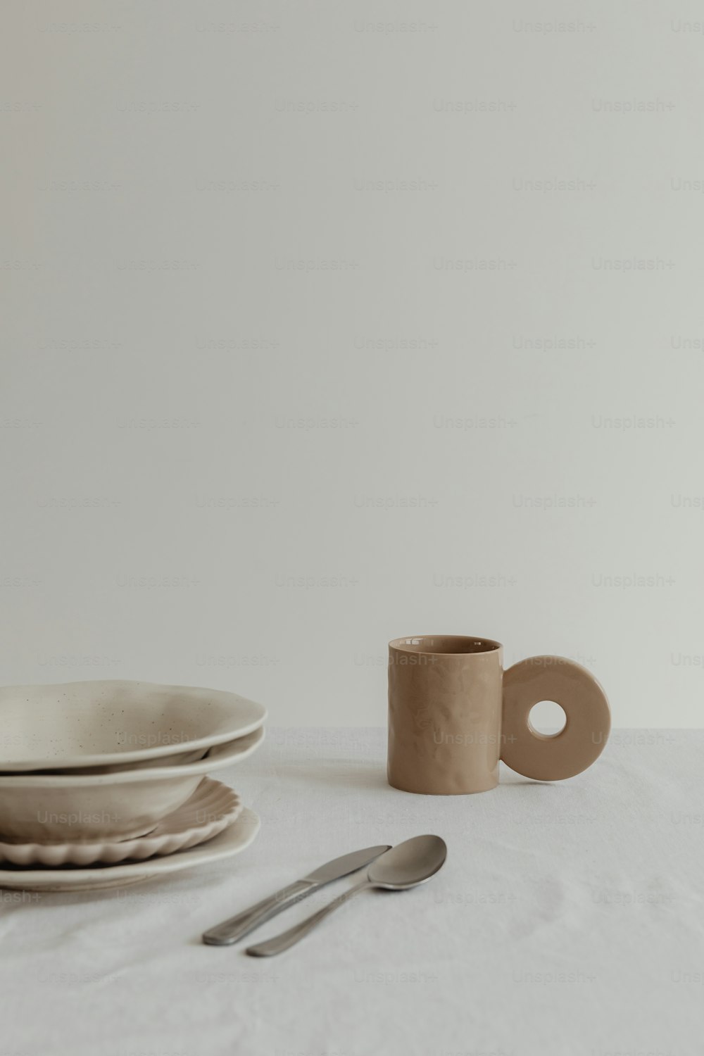 una mesa cubierta con un plato blanco y una taza