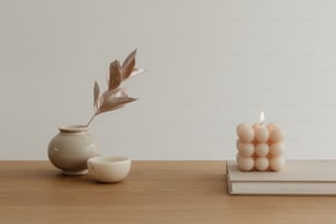 eine Kerze und eine Vase auf einem Tisch