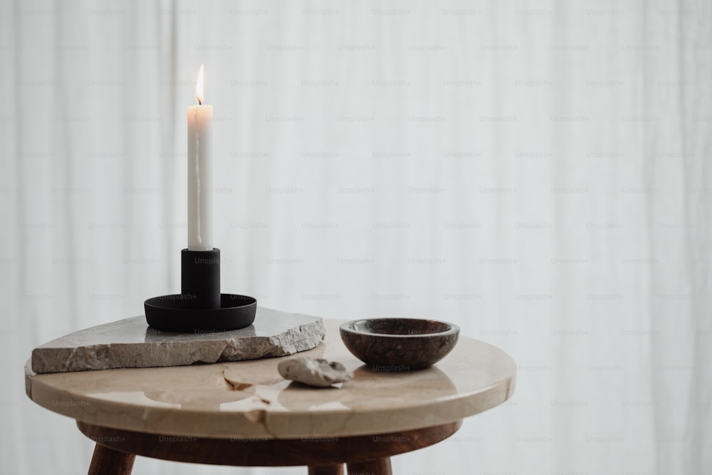 a table with a candle and a bowl on it