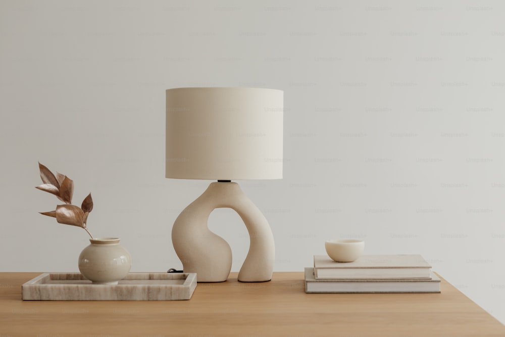 uma mesa com uma lâmpada e um vaso sobre ela