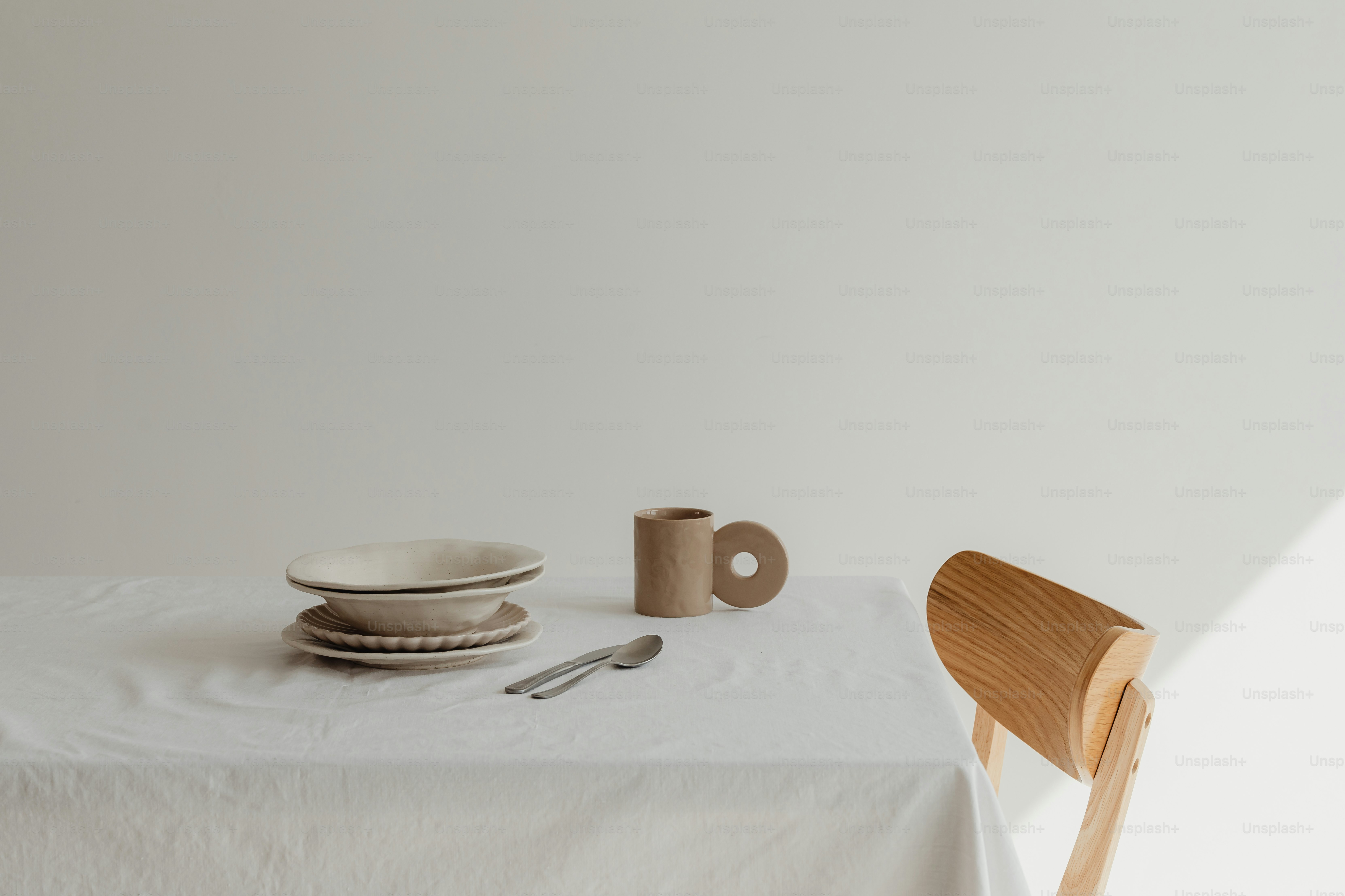 a table with a white table cloth and a wooden chair