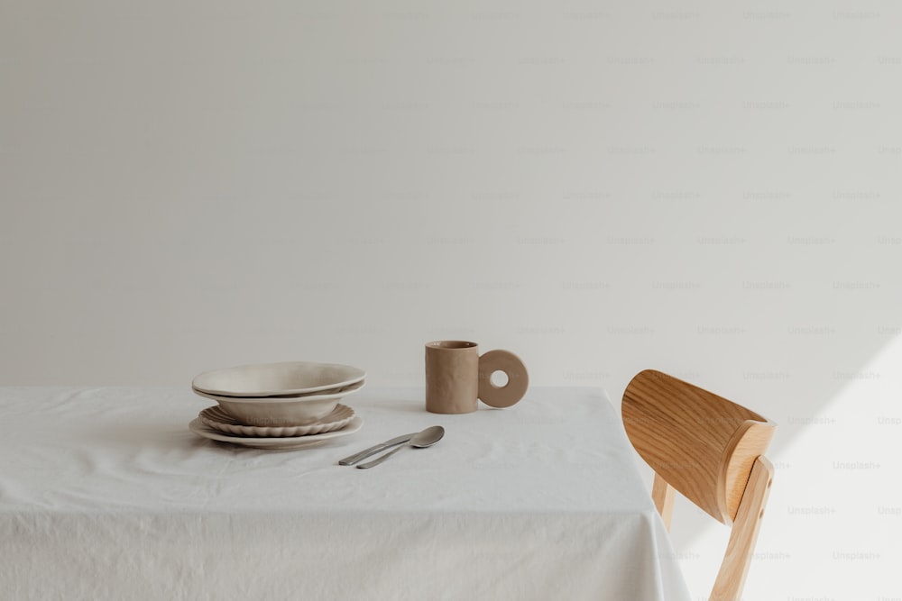 un tavolo con una tovaglia bianca e una sedia di legno
