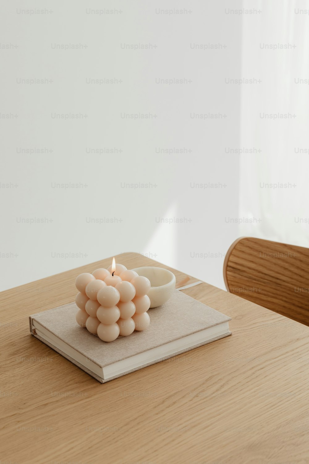 Eine Kerze, die auf einem Buch auf einem Tisch sitzt