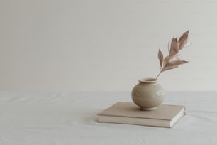 um livro e um vaso sobre uma mesa