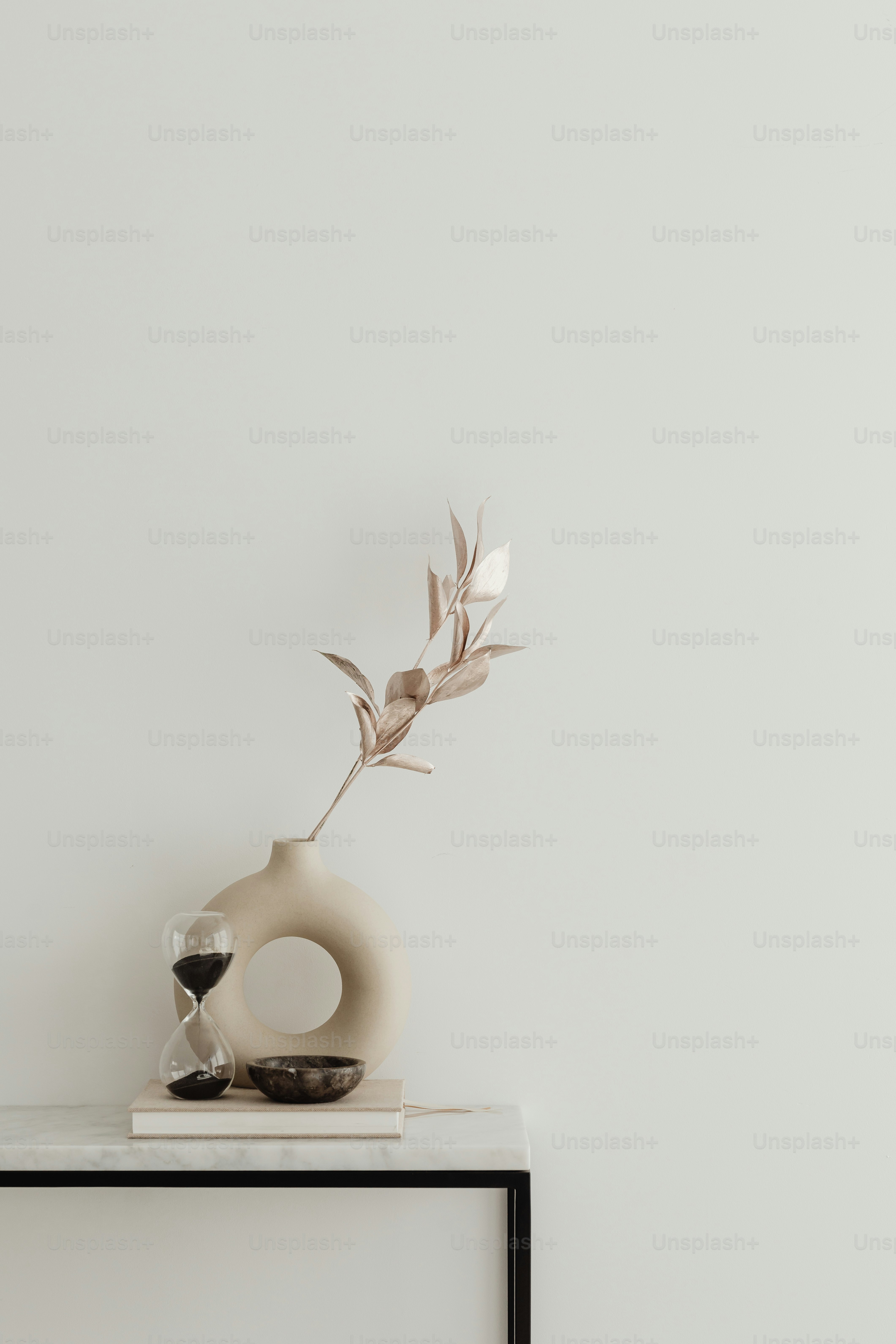 a white vase sitting on top of a table