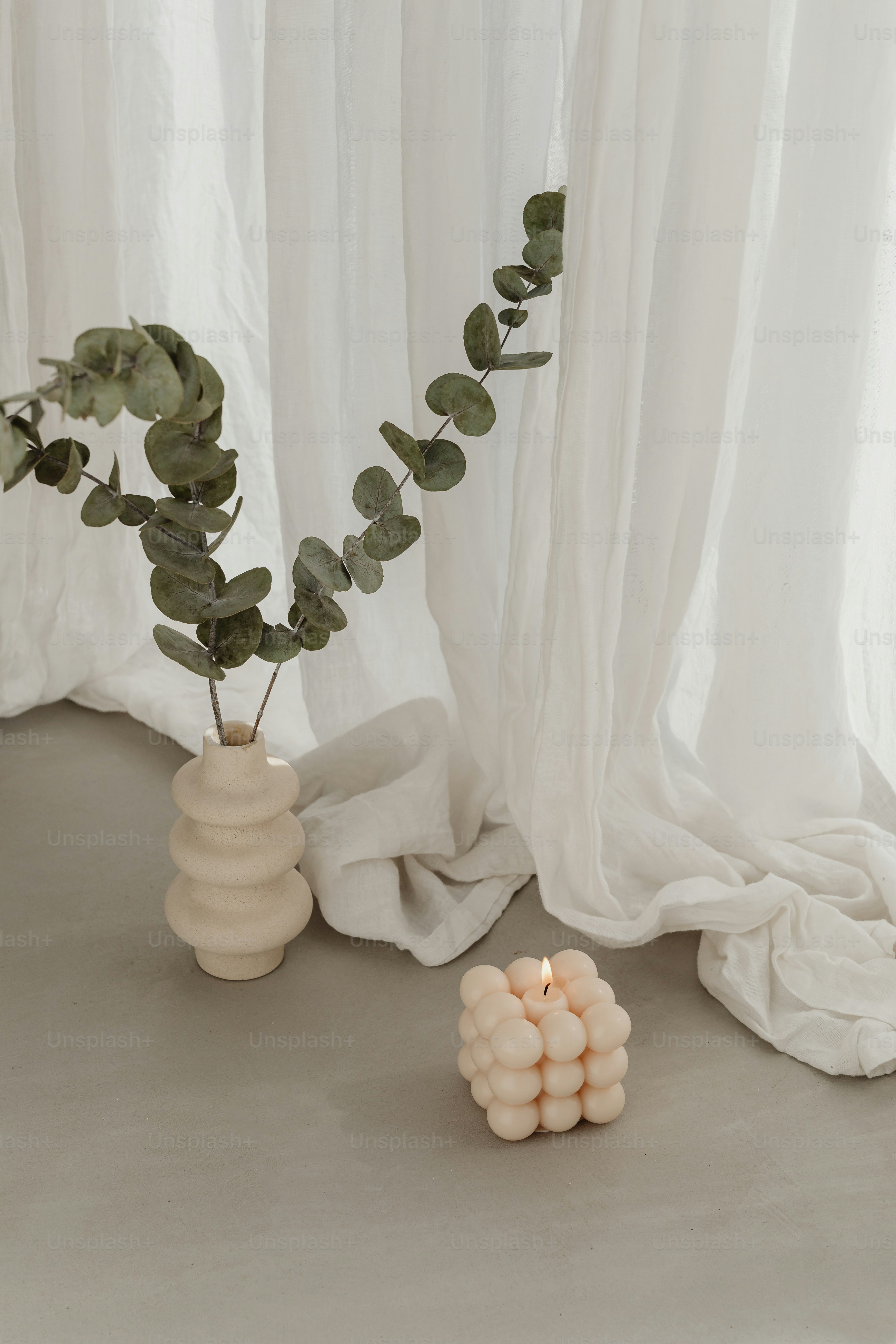 ろうそくの隣に植物が入った花瓶