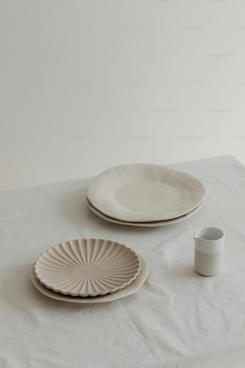 a table topped with two plates and a cup