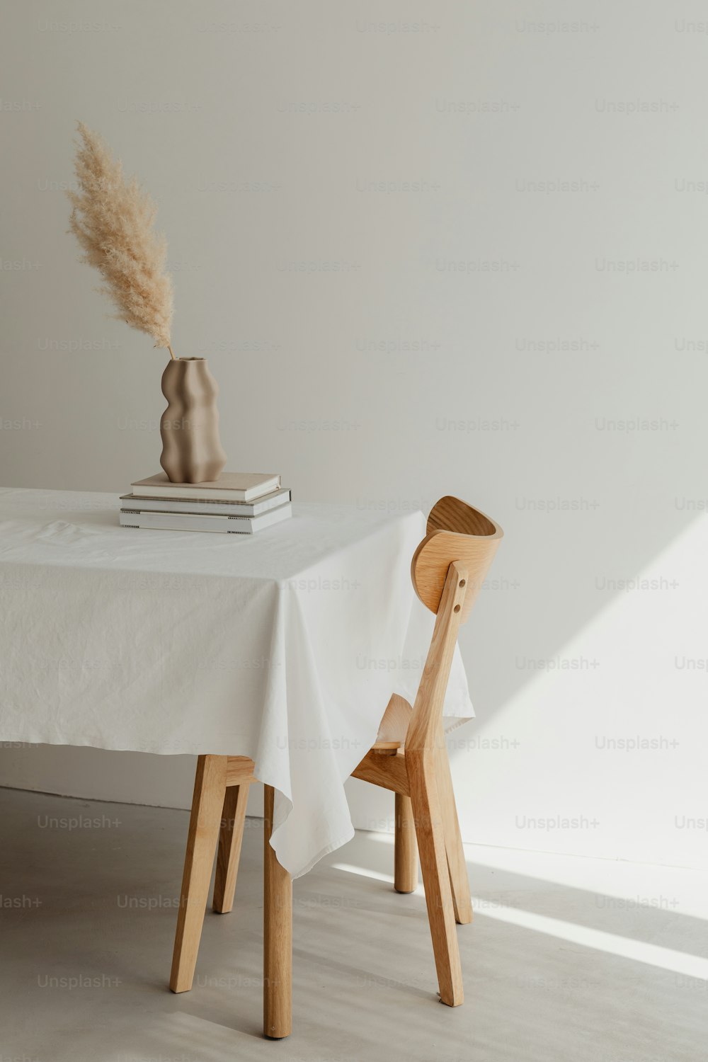 una mesa con un mantel blanco y una silla de madera