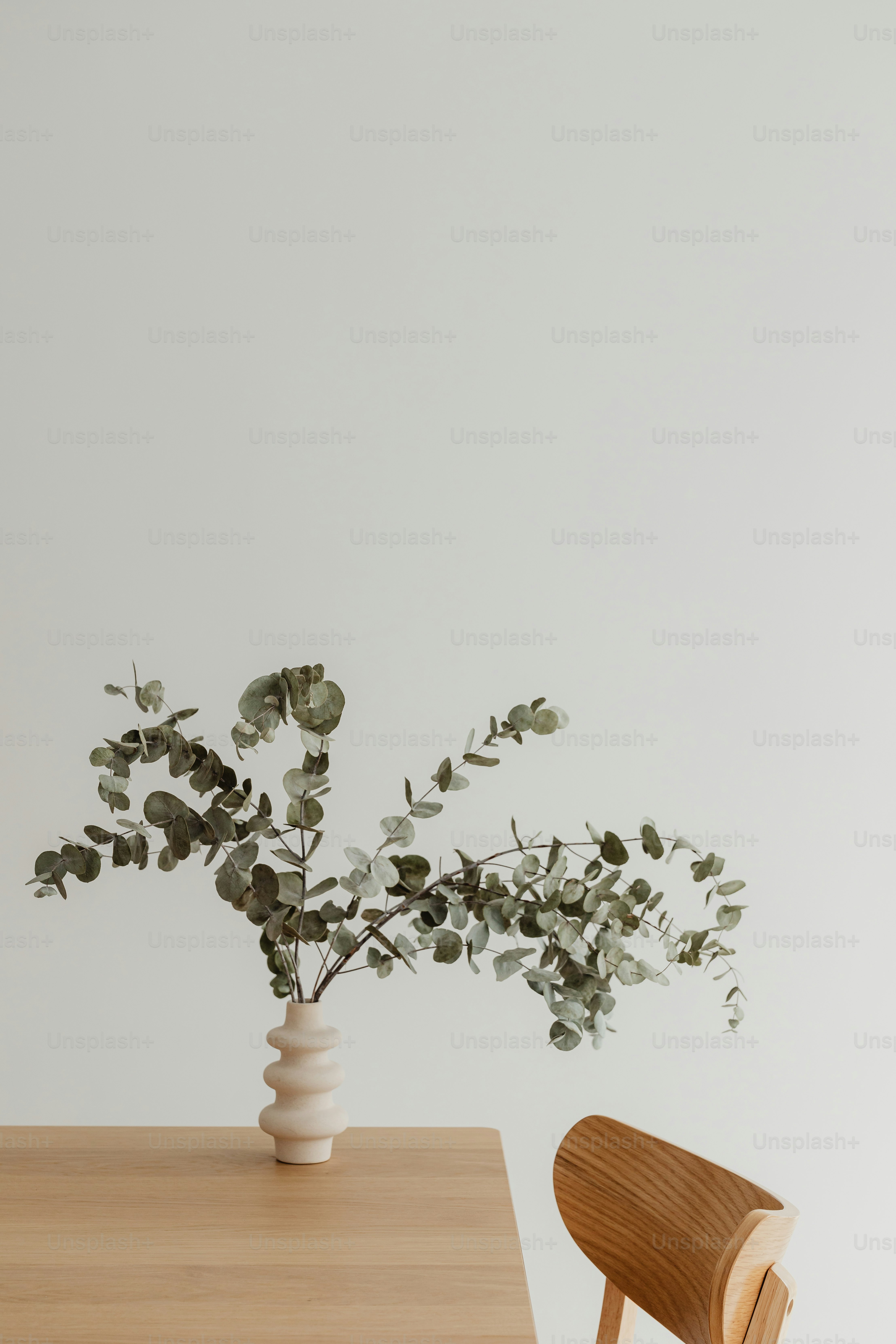 uma mesa com uma cadeira e um vaso com uma planta nela