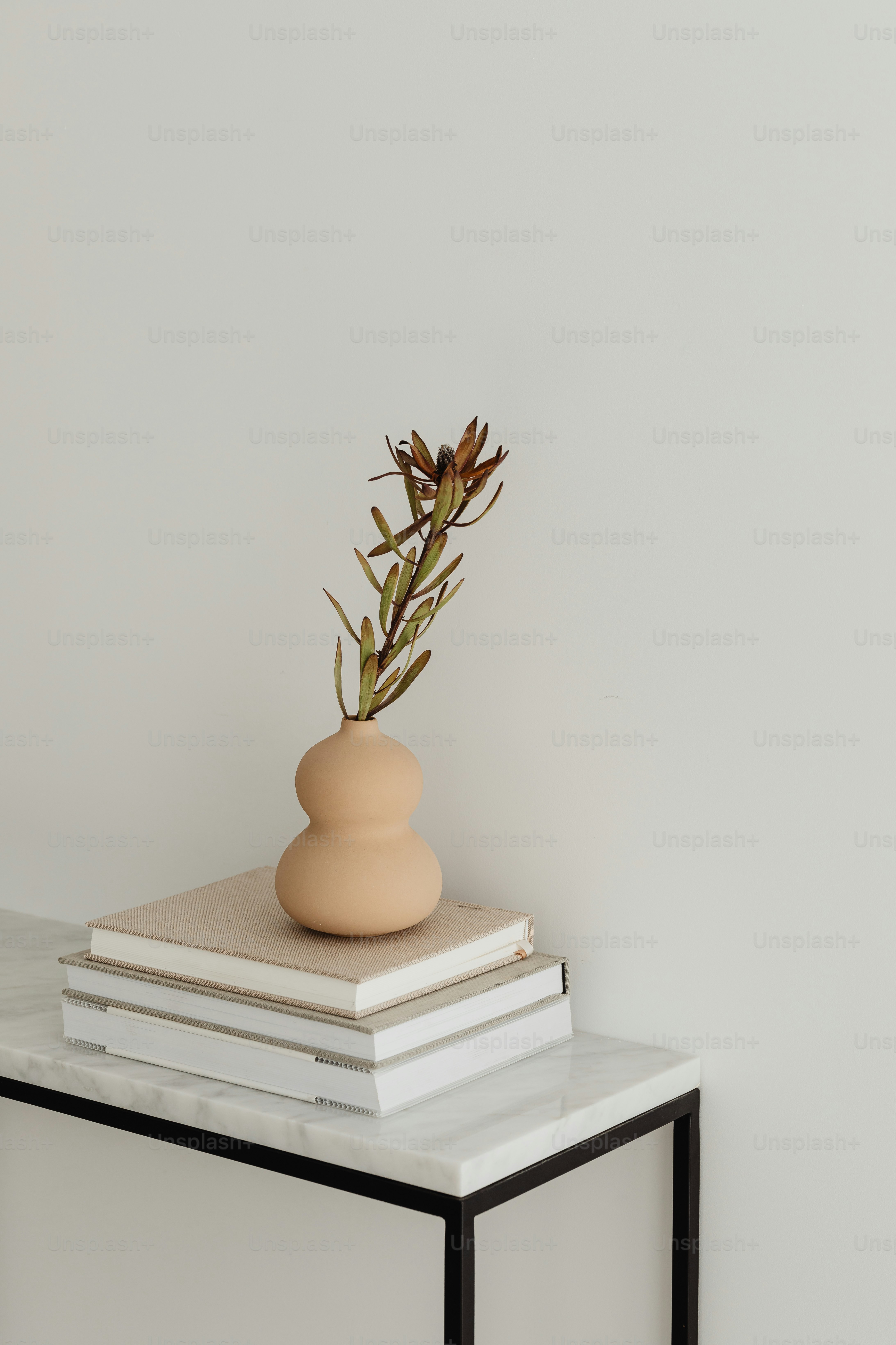 ein Stapel Bücher und eine Vase auf einem Tisch