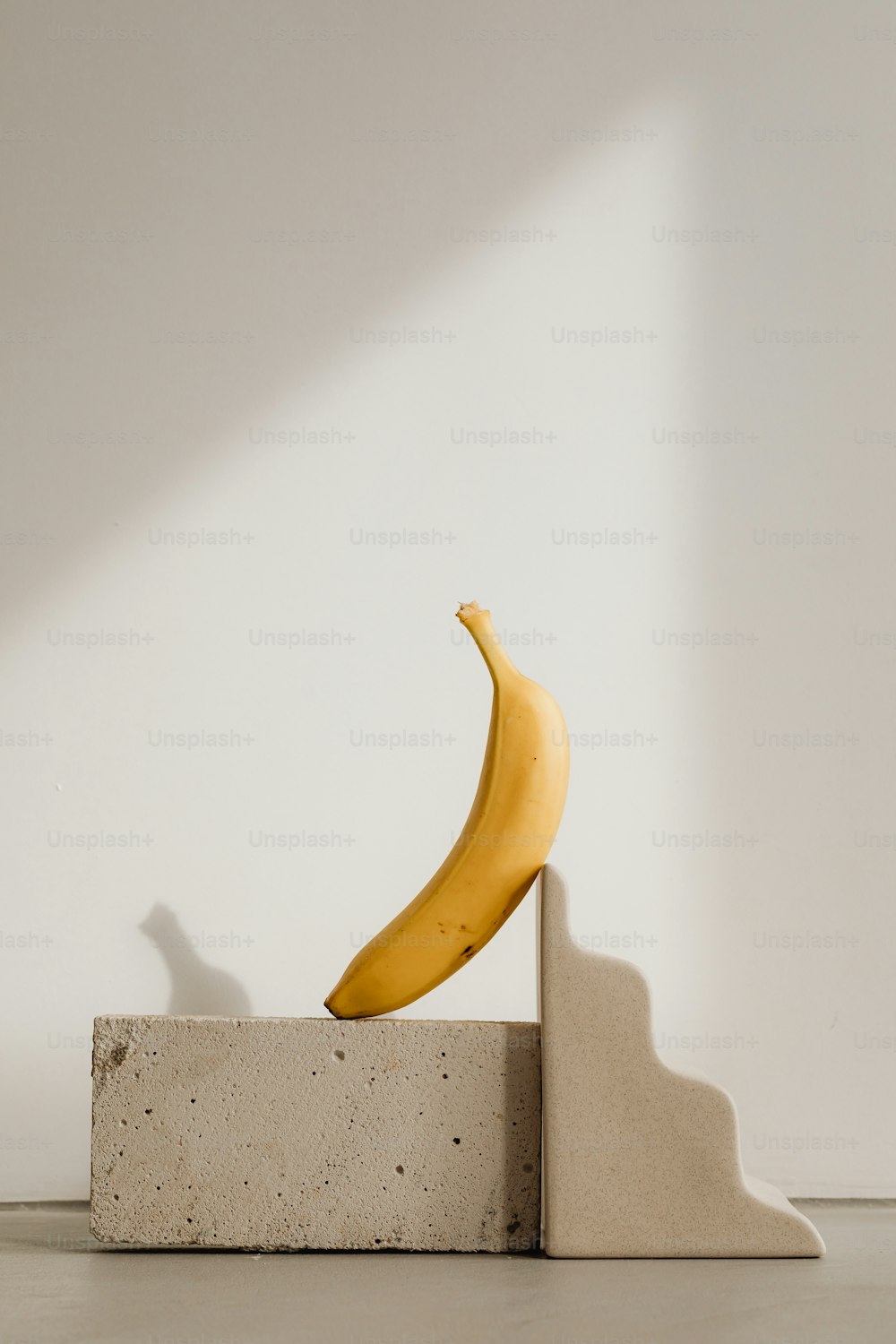 eine Banane, die auf einem Zementblock sitzt