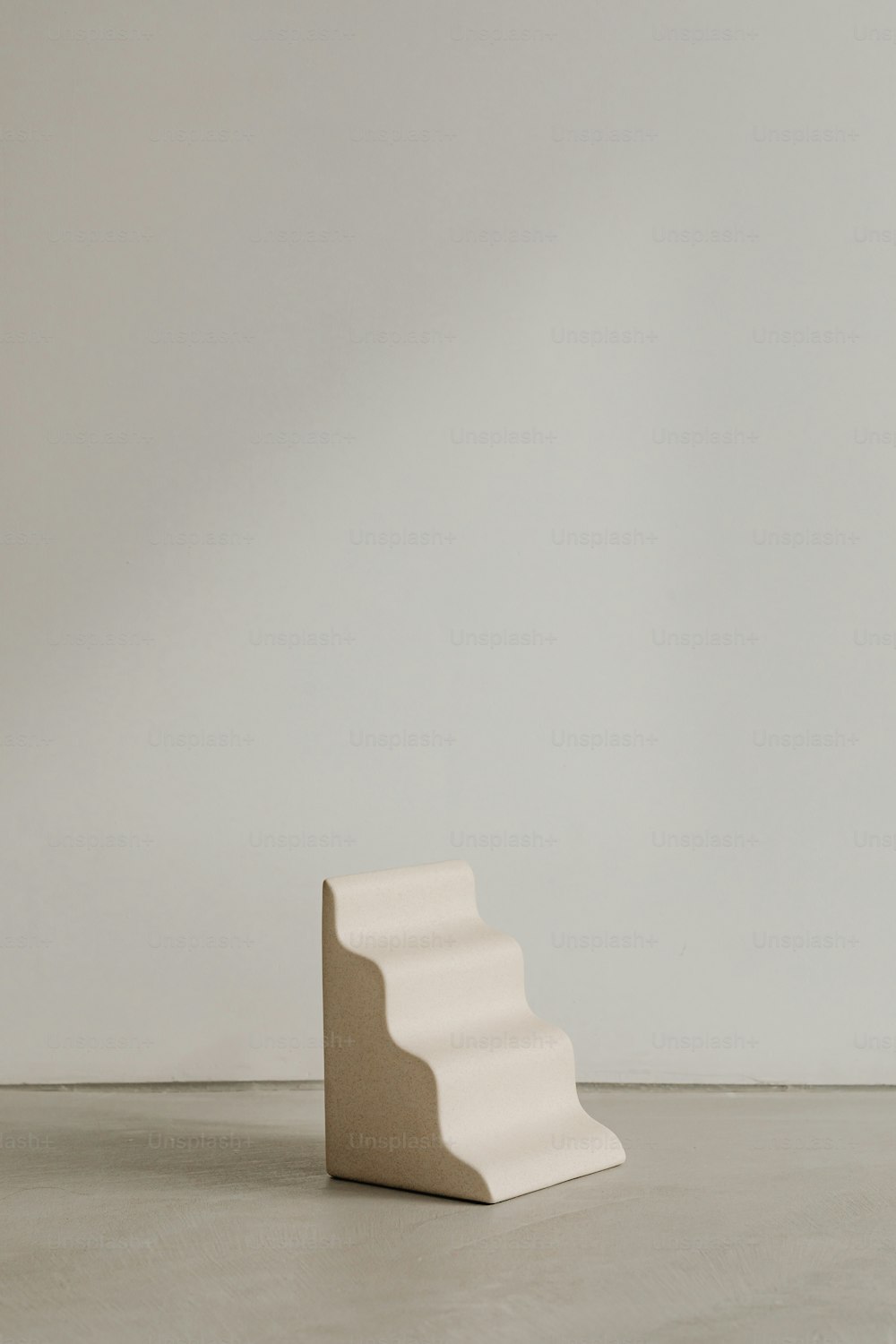 una scultura bianca seduta sopra un pavimento di cemento