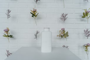 eine weiße Vase, die auf einem weißen Tisch sitzt