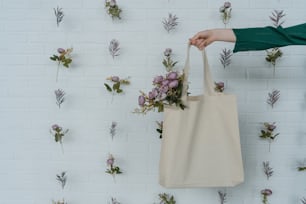 a person holding a tote bag with flowers on it