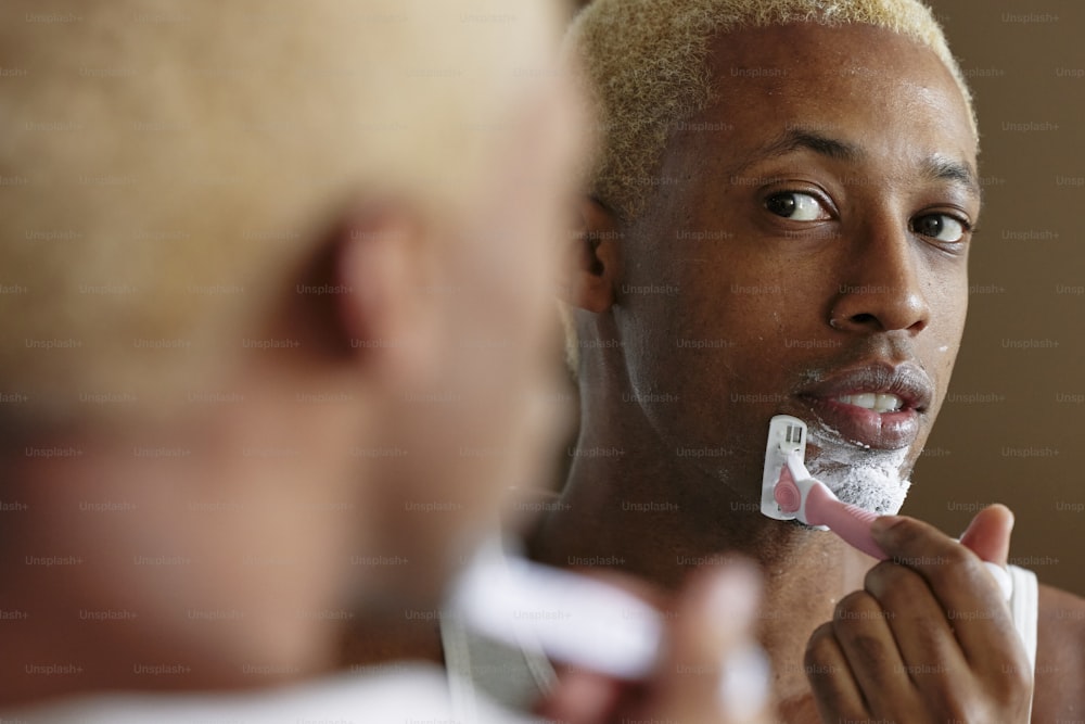 a man shaving his face with a razor