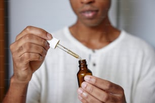 a man holding a bottle of essential oil