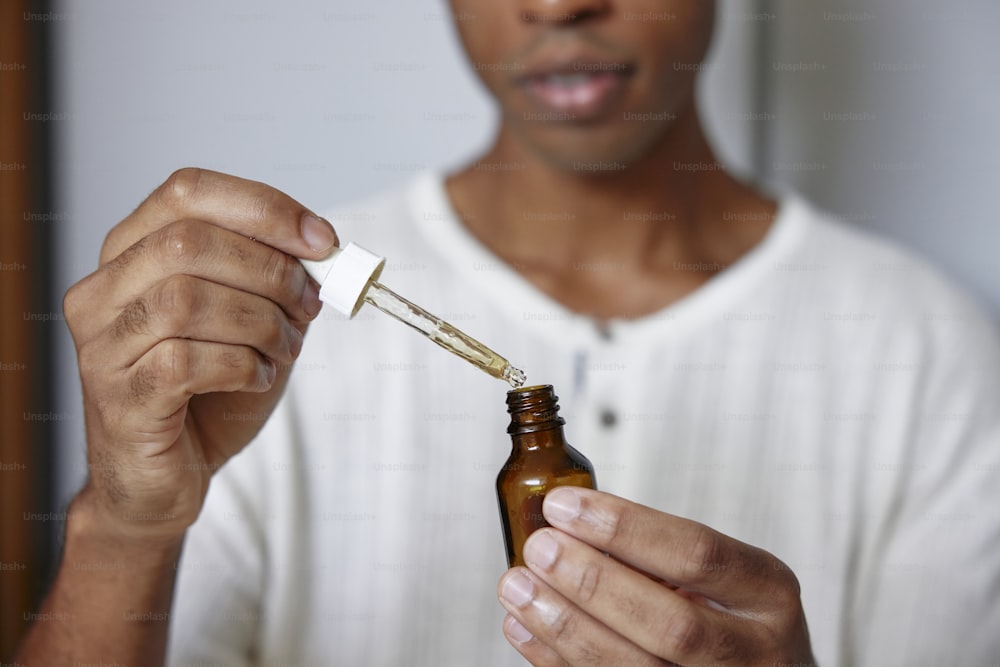 a man holding a bottle of essential oil