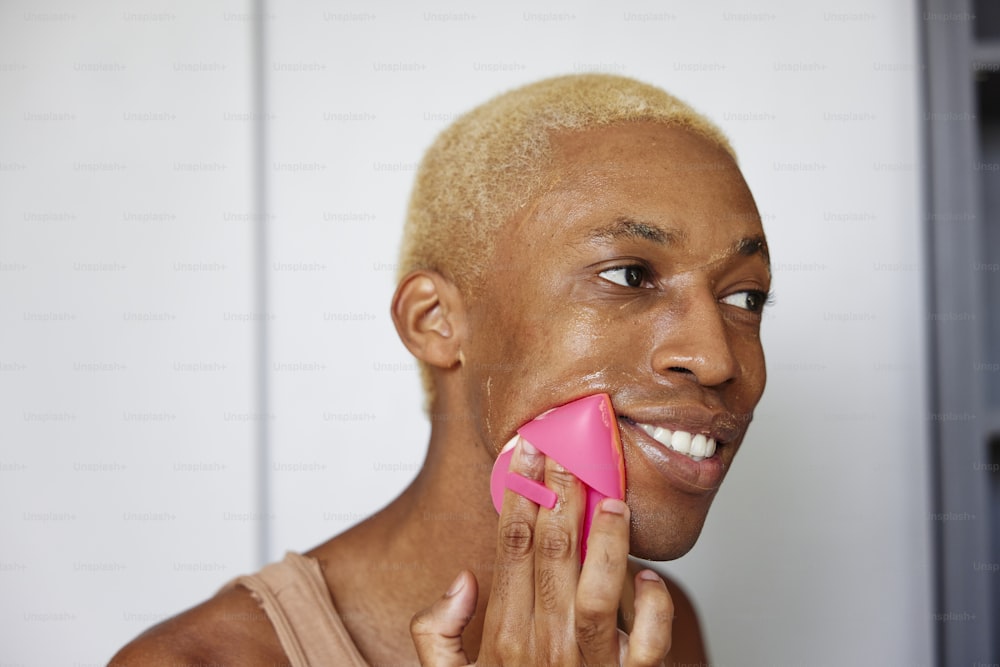 um homem com um objeto rosa na boca