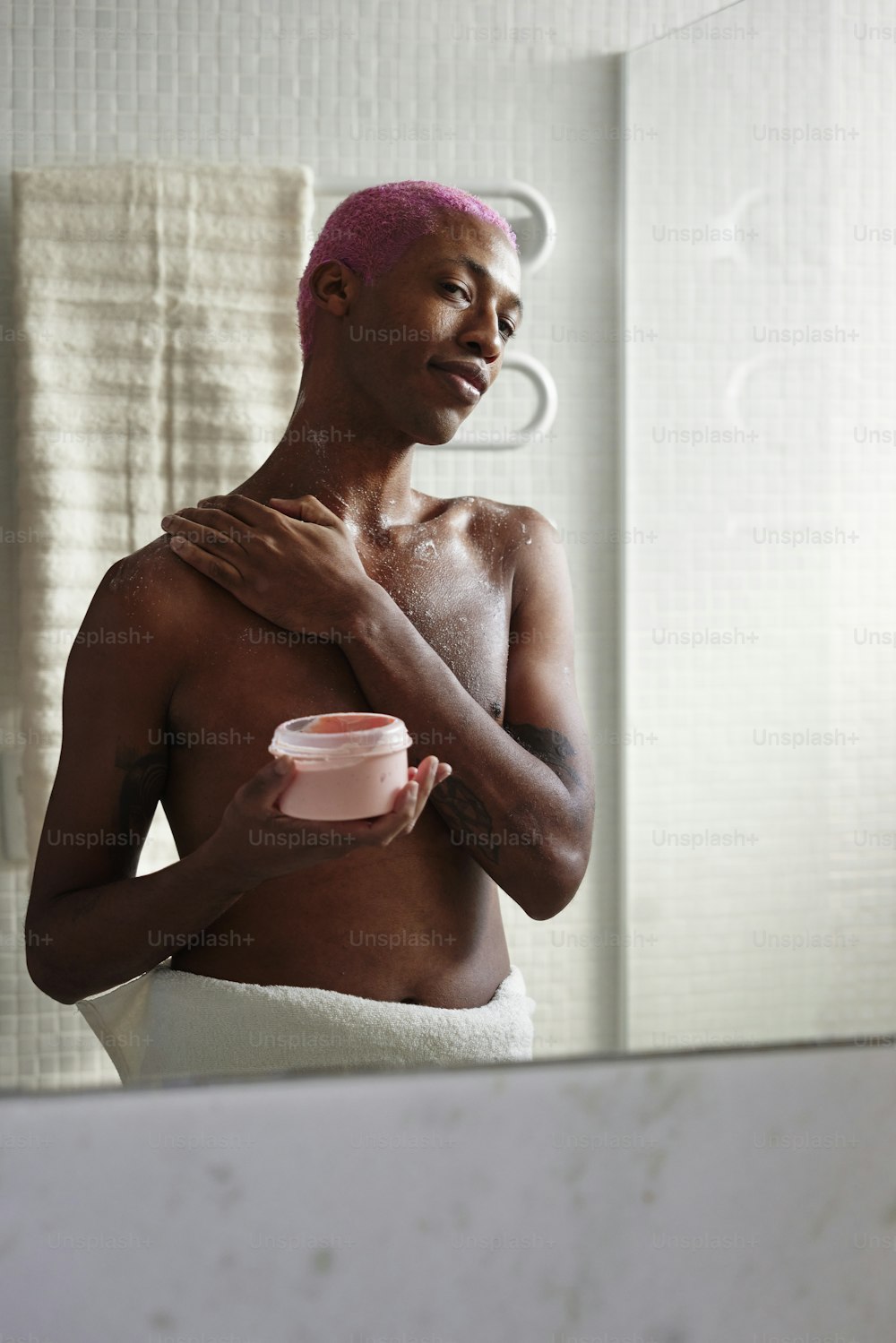 a man with a pink towel on his head and a cup in his hand