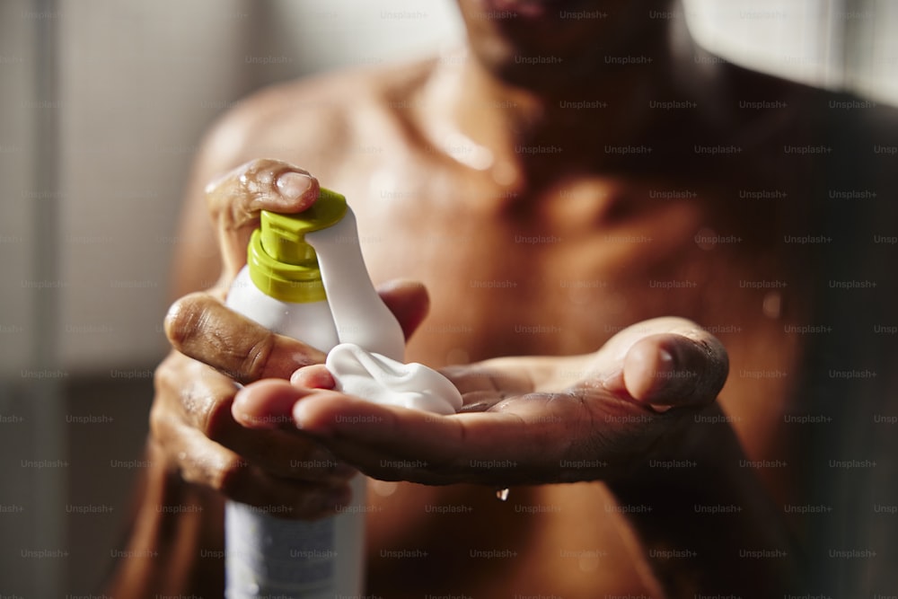 a man holding a bottle of lotion in his hands