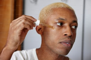 a man with a yellow hair combing his hair