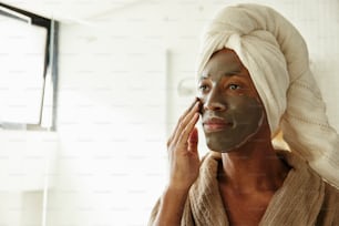 a woman with a towel on her head and a face mask on