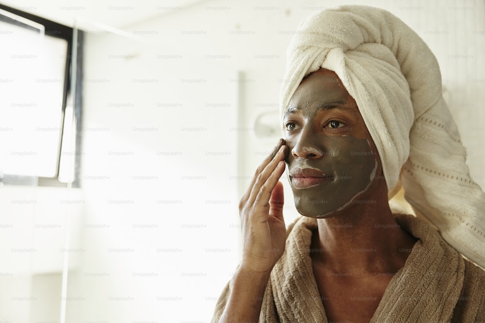 a woman with a towel on her head and a face mask on