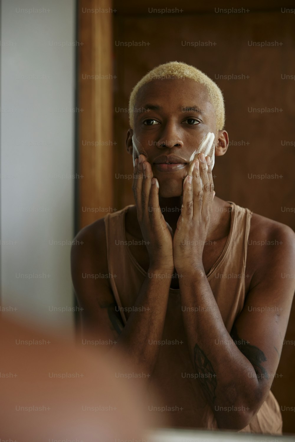 Une femme se rase le visage devant un miroir