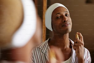 ein Mann mit einem Handtuch auf dem Kopf, der sich die Zähne putzt