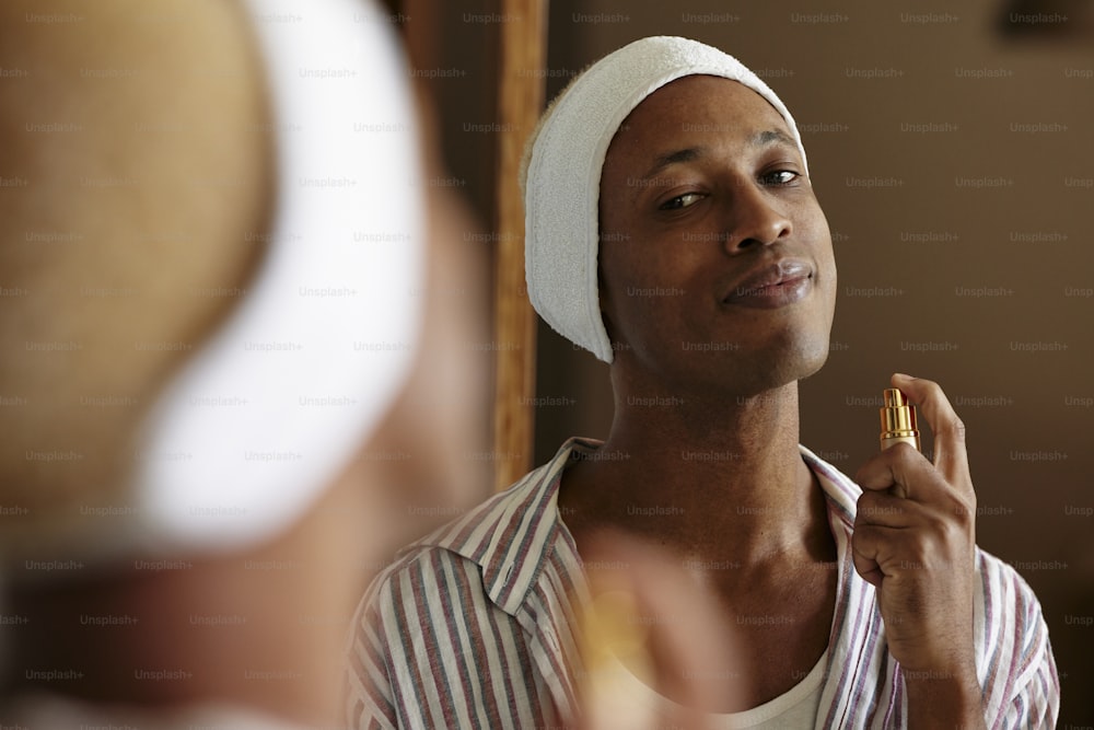 a man with a towel on his head brushing his teeth