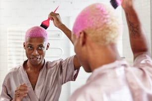 Une femme aux cheveux roses se sèche les cheveux