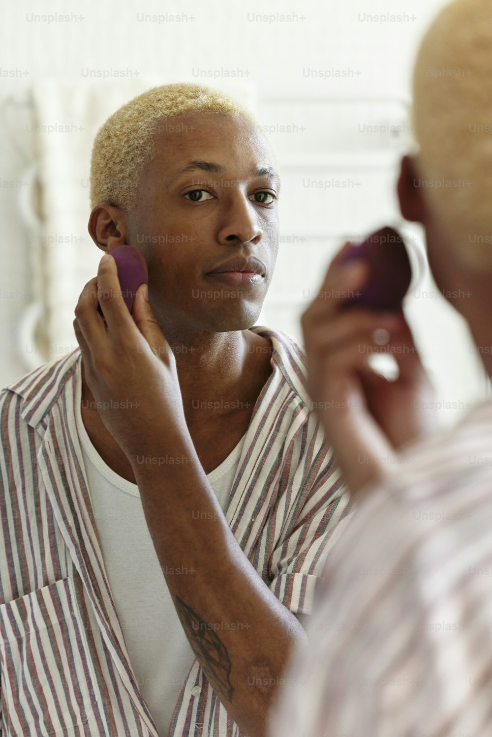 a man in a striped shirt is brushing his hair