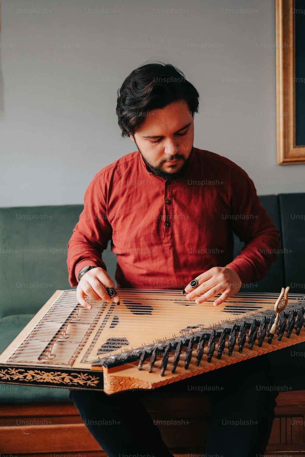 a man sitting on a couch playing a musical instrument