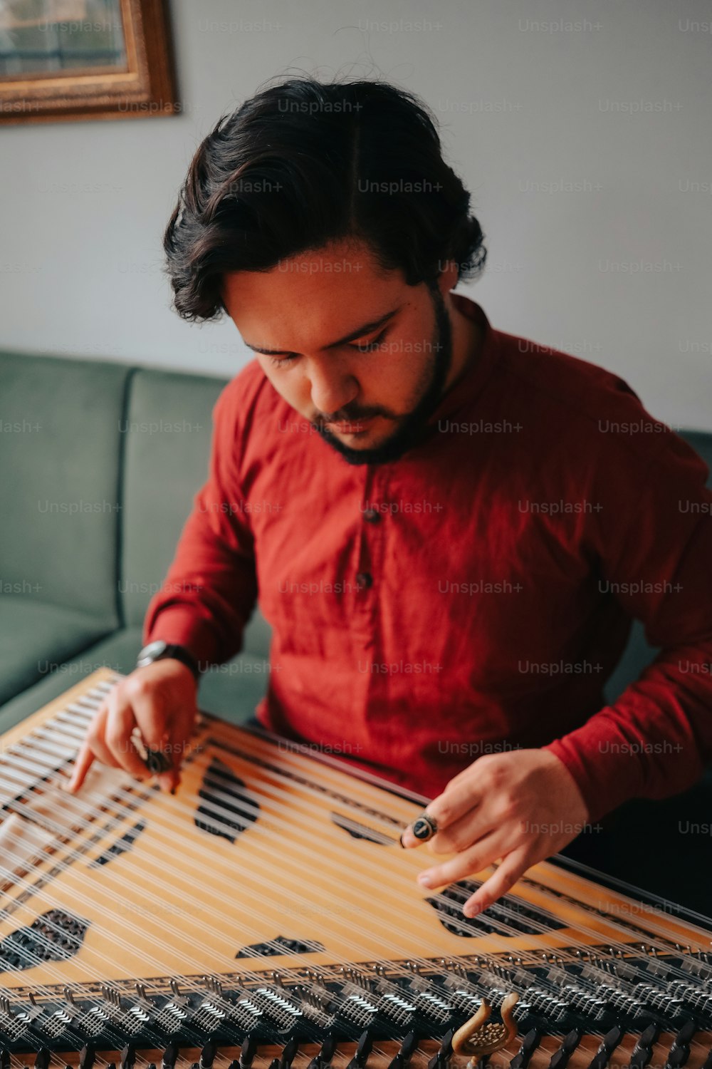Un uomo con una camicia rossa sta suonando uno strumento musicale