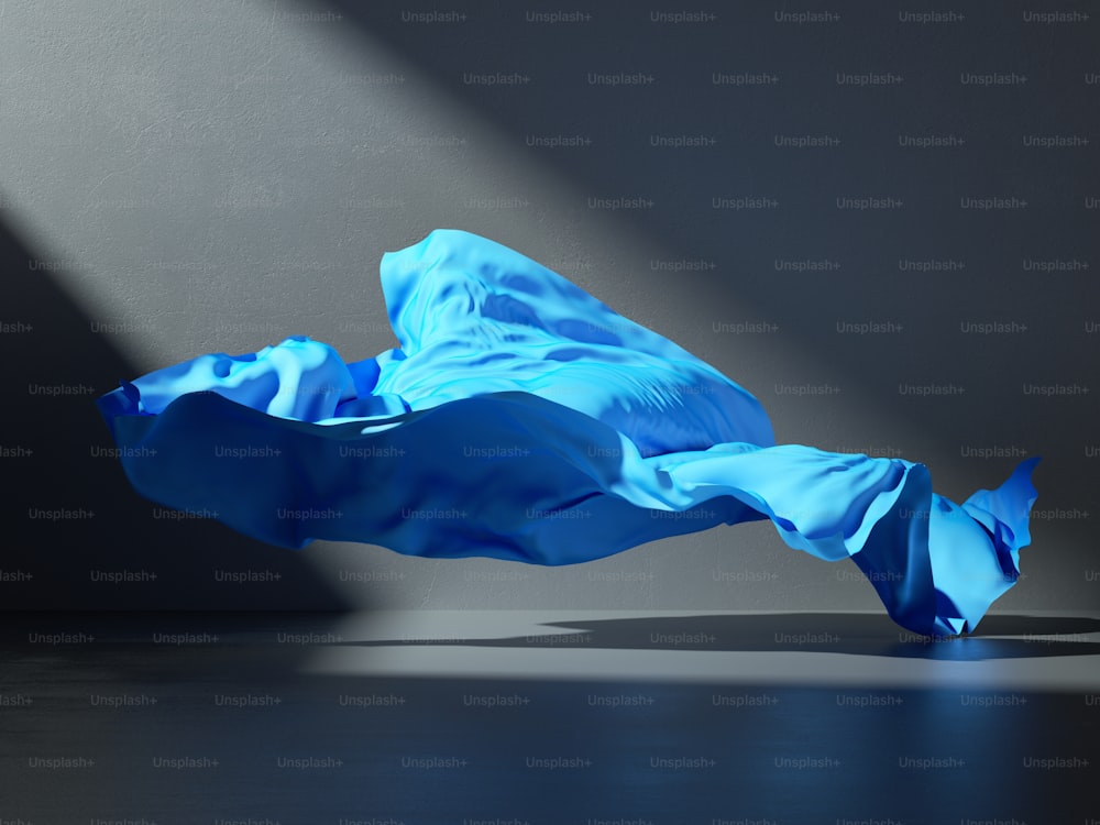 3d render. Abstract fashion background with blue drapery falling on the floor inside the dark room illuminated with light. Silk textile is blown away by the wind