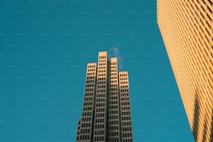 two tall buildings with a blue sky in the background