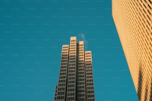 two tall buildings with a blue sky in the background