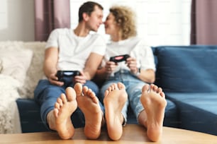 Jovem casal feliz com gamepads estão jogando console de videogame
