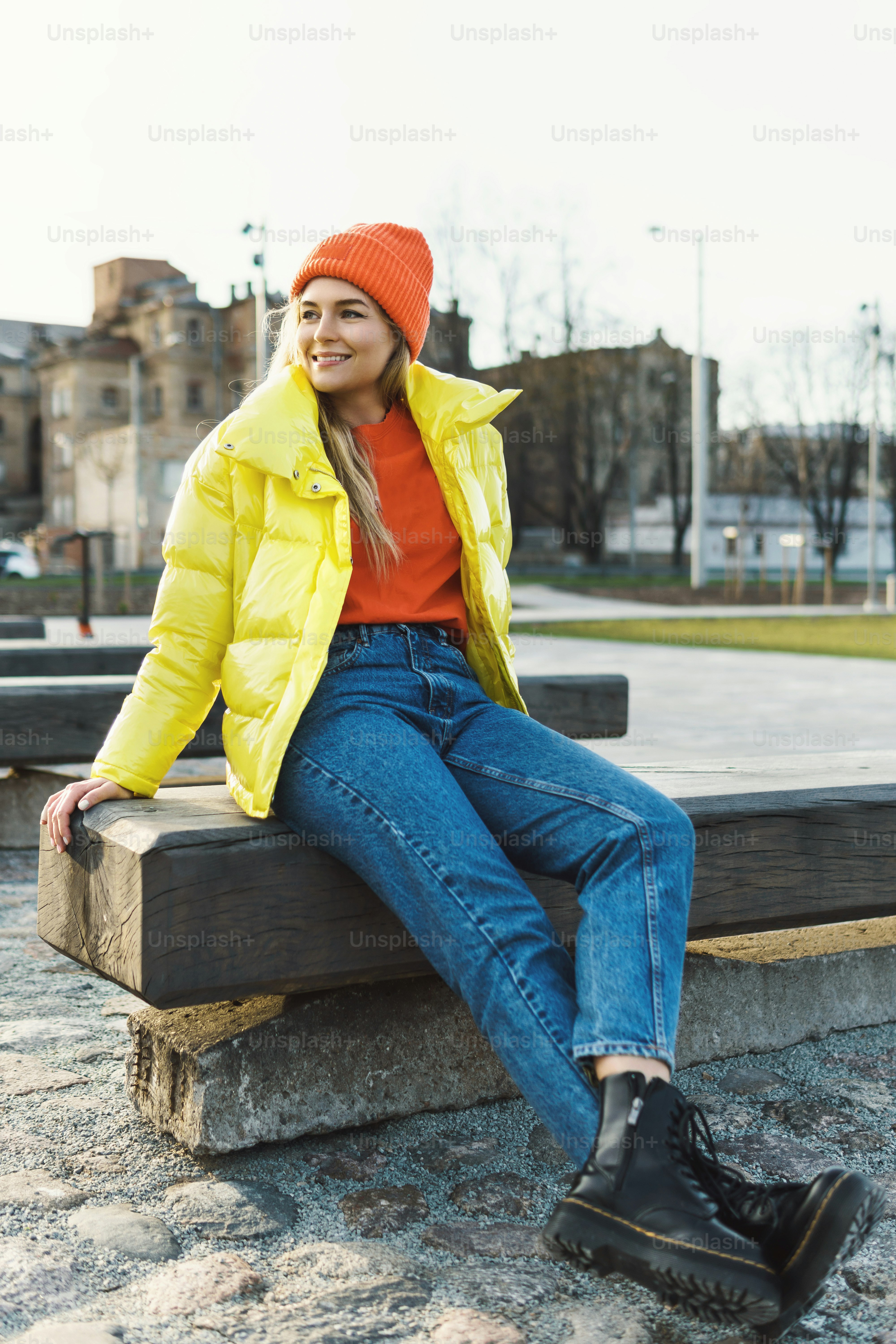 Portrait of  stylish girl wearing yellow puffer and orange knitted hat