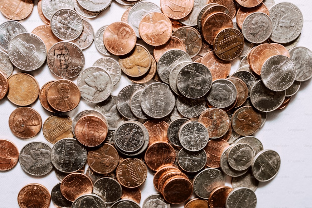 una pila di monete seduta sopra un tavolo bianco