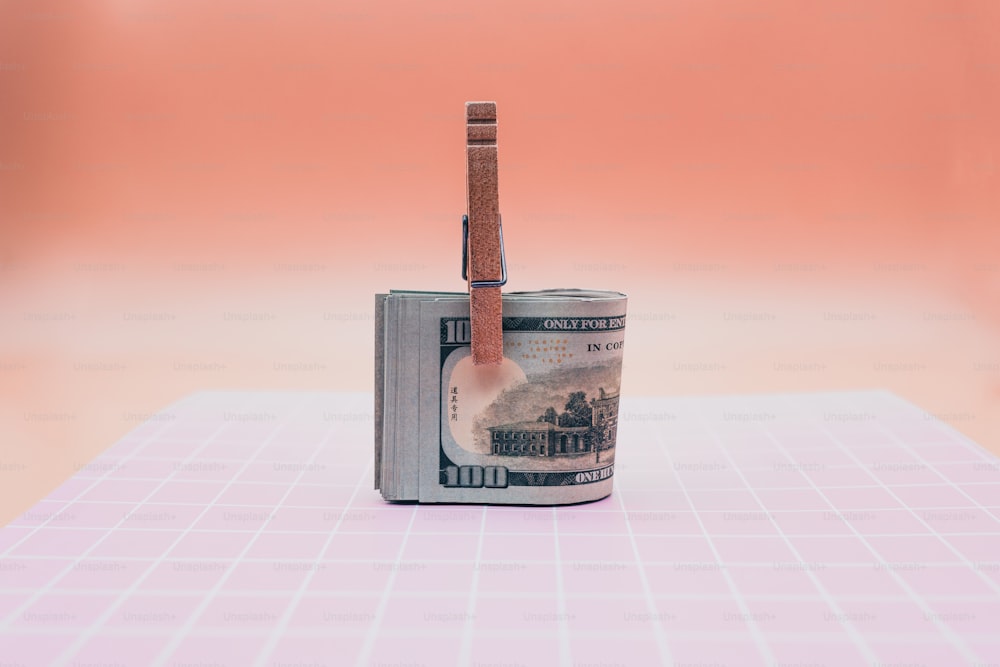 a roll of money with a toothbrush sticking out of it