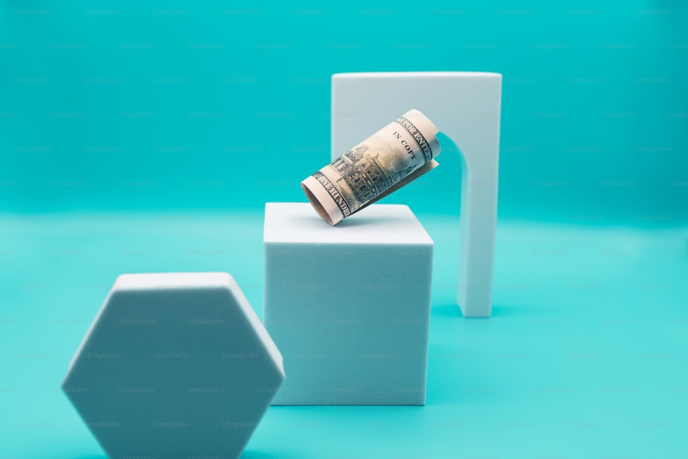 a stack of money sitting on top of a white block