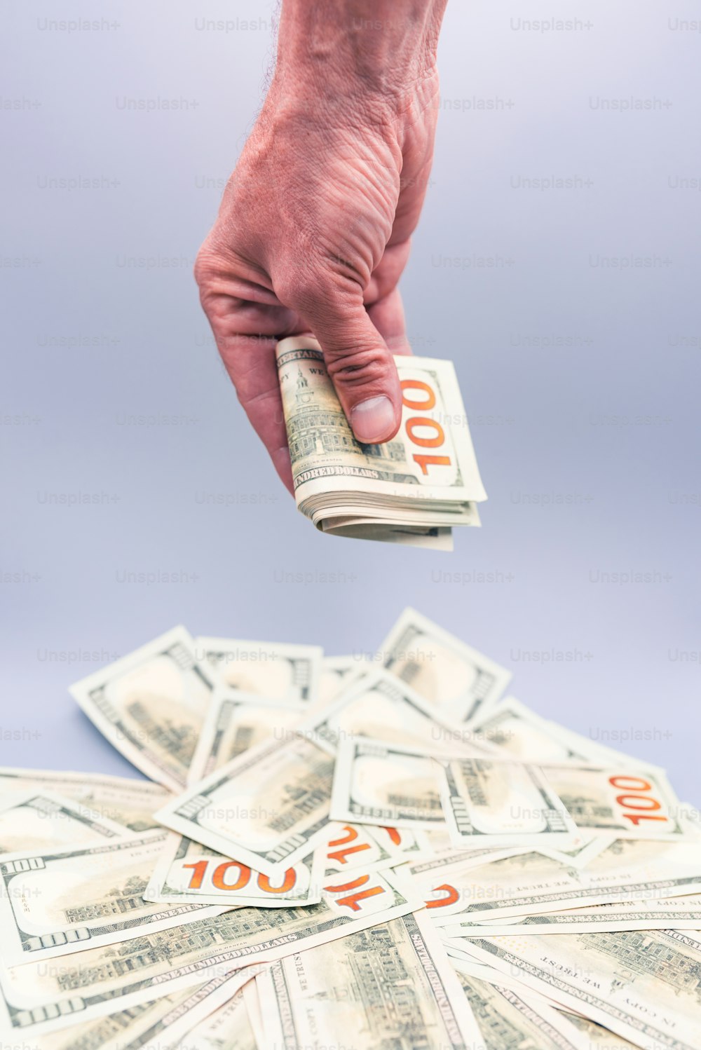 a person is holding a stack of money