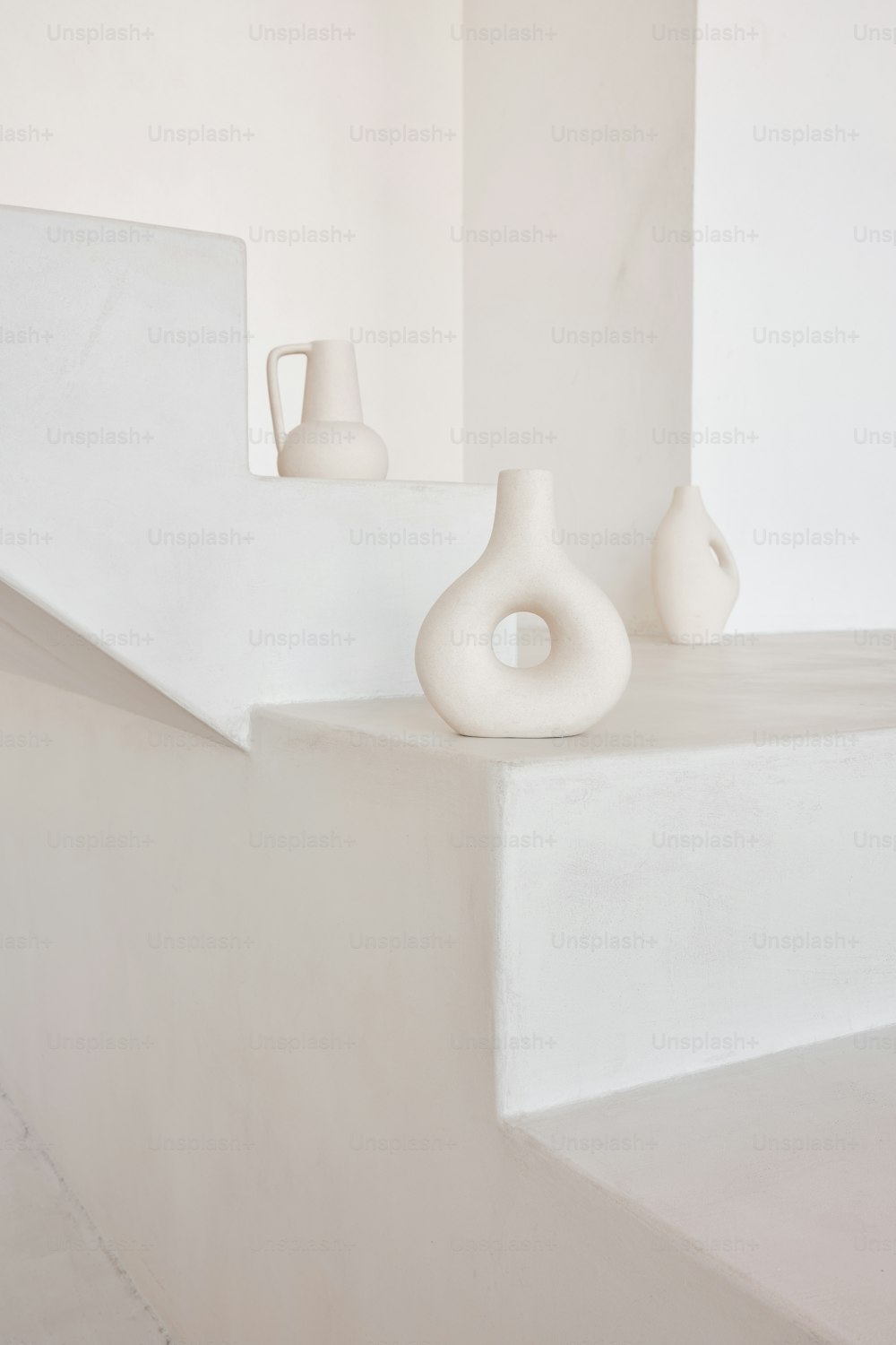 a couple of white vases sitting on a ledge