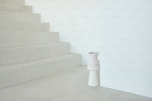 a white vase sitting on top of a set of stairs