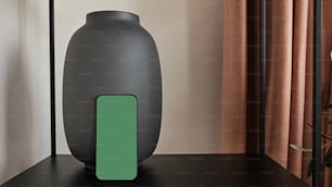eine Vase, die auf einem Tisch neben einem Fenster sitzt