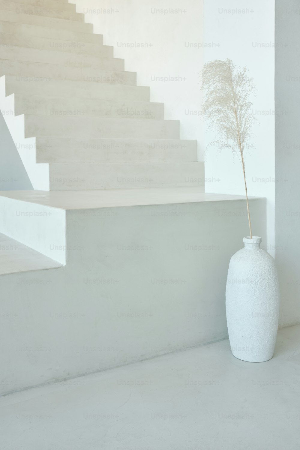 eine weiße Vase mit einer Pflanze darin neben einem Treppenhaus