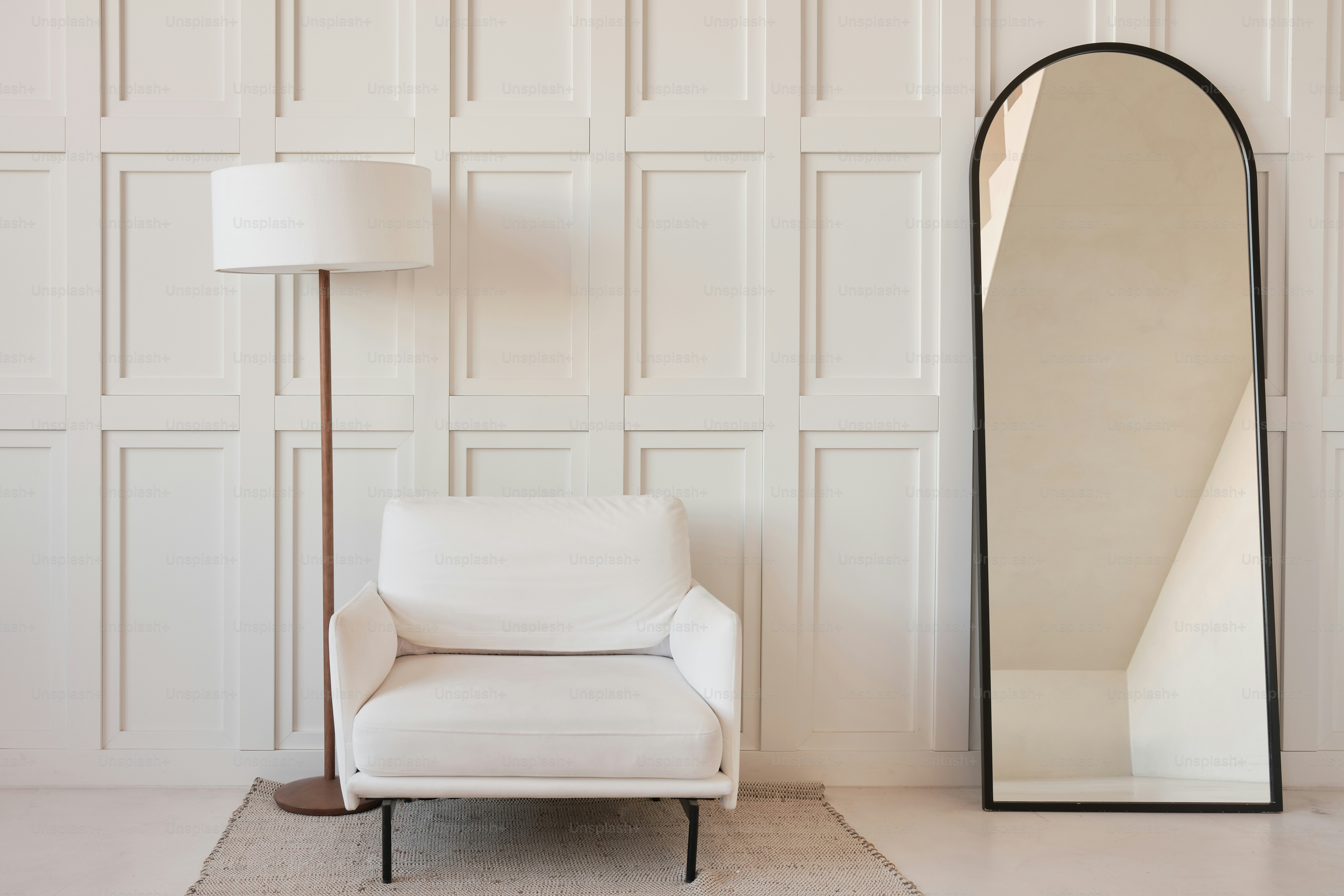 una silla blanca y un gran espejo en una habitación