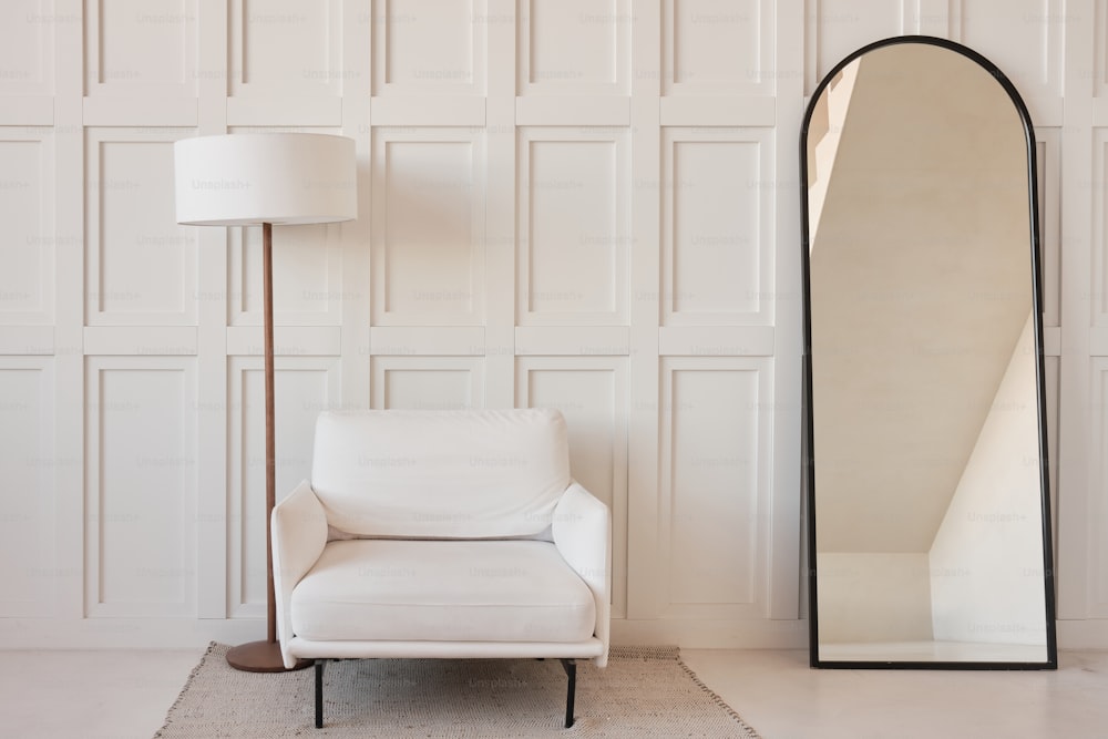 una sedia bianca e un grande specchio in una stanza